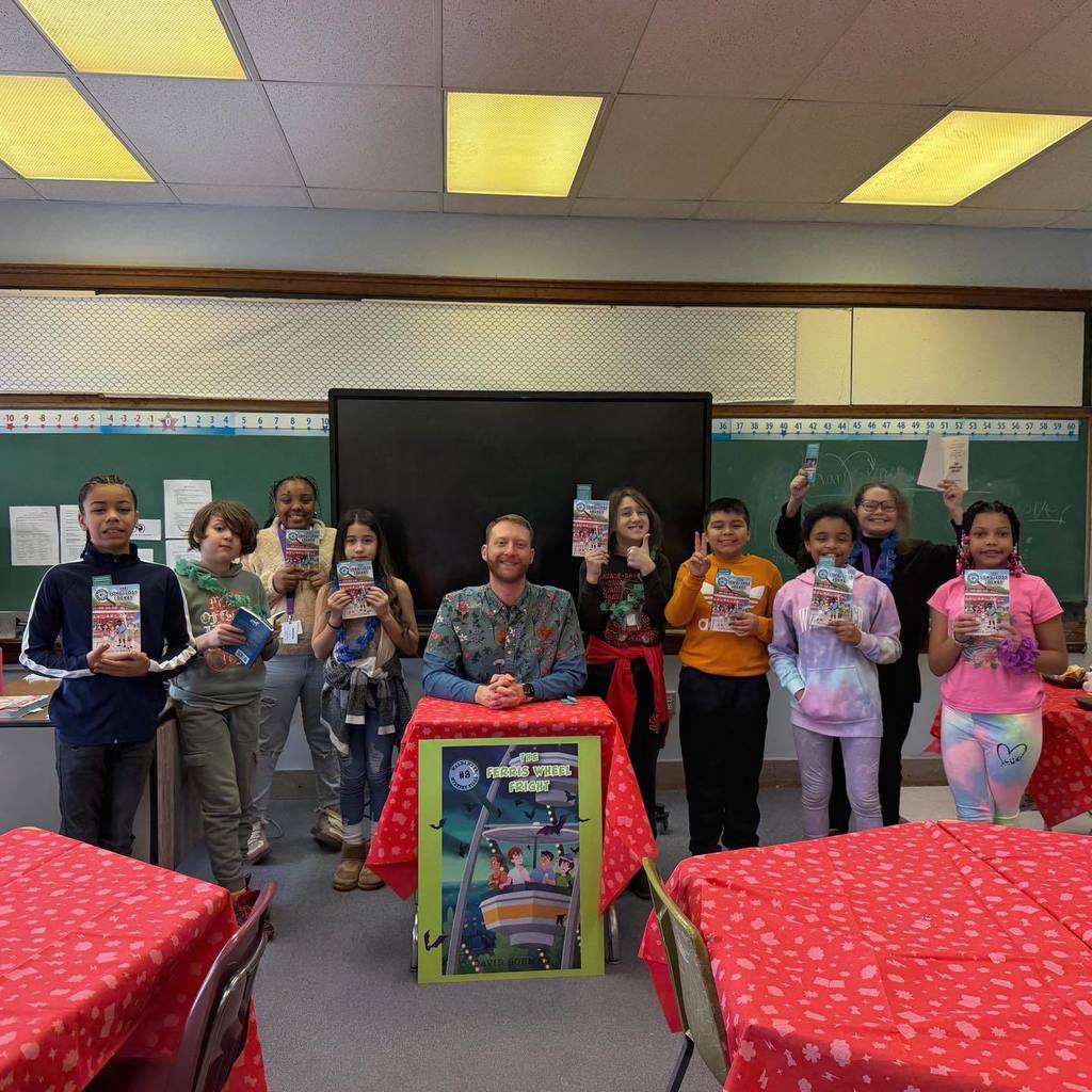 A man sitting in front of his book cover and students standing next to him holding books.