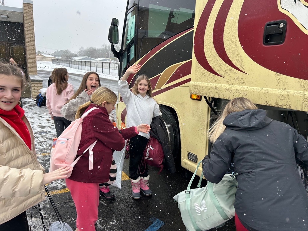 6th grade students loading up luggage on buses to head to Camp Fitch