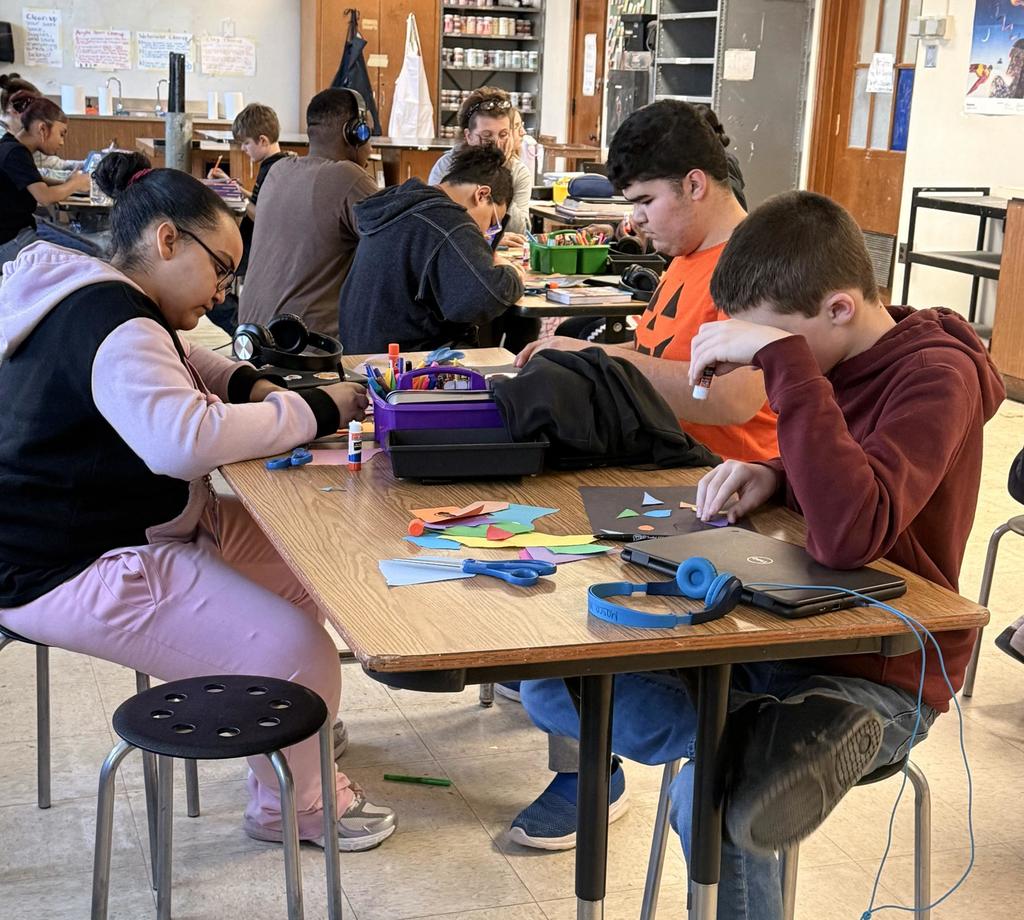 Students doing a craft in class using colorful paper. 