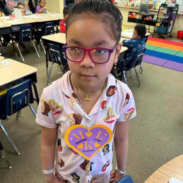 A student wearing a large purple heart as a necklace.