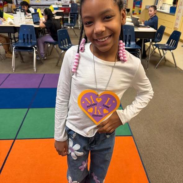 A student wearing a large purple heart as a necklace.