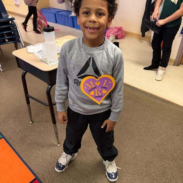 A student wearing a large purple heart as a necklace.
