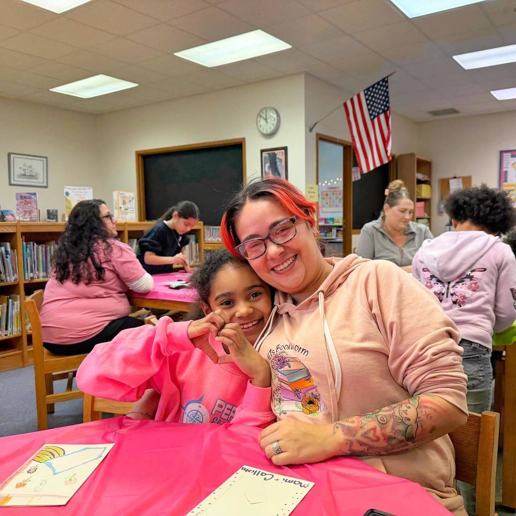 A mother and daughter smiling and hugging.