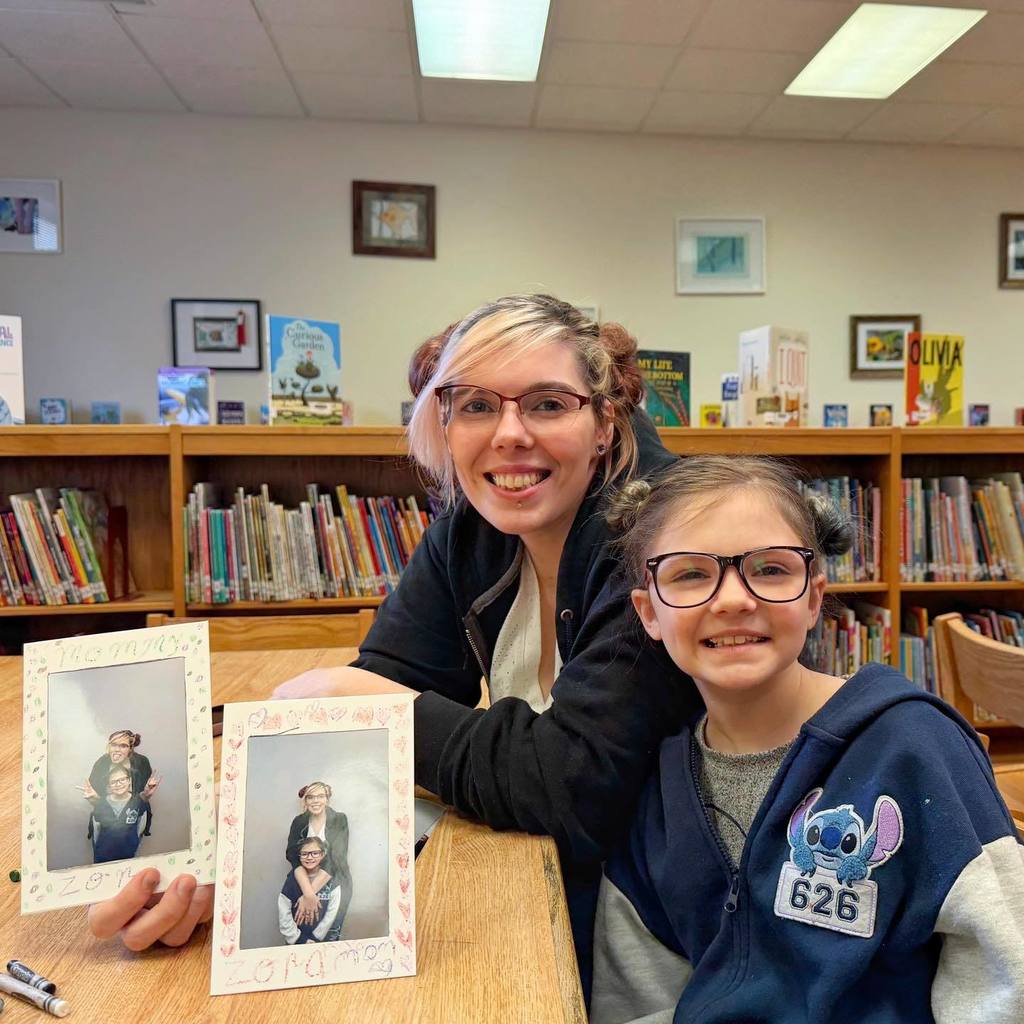 A mother and daughter showing the frames the decorated with their photo inside. 