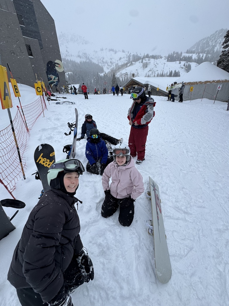 Four boarders bundling up to hit the slopes