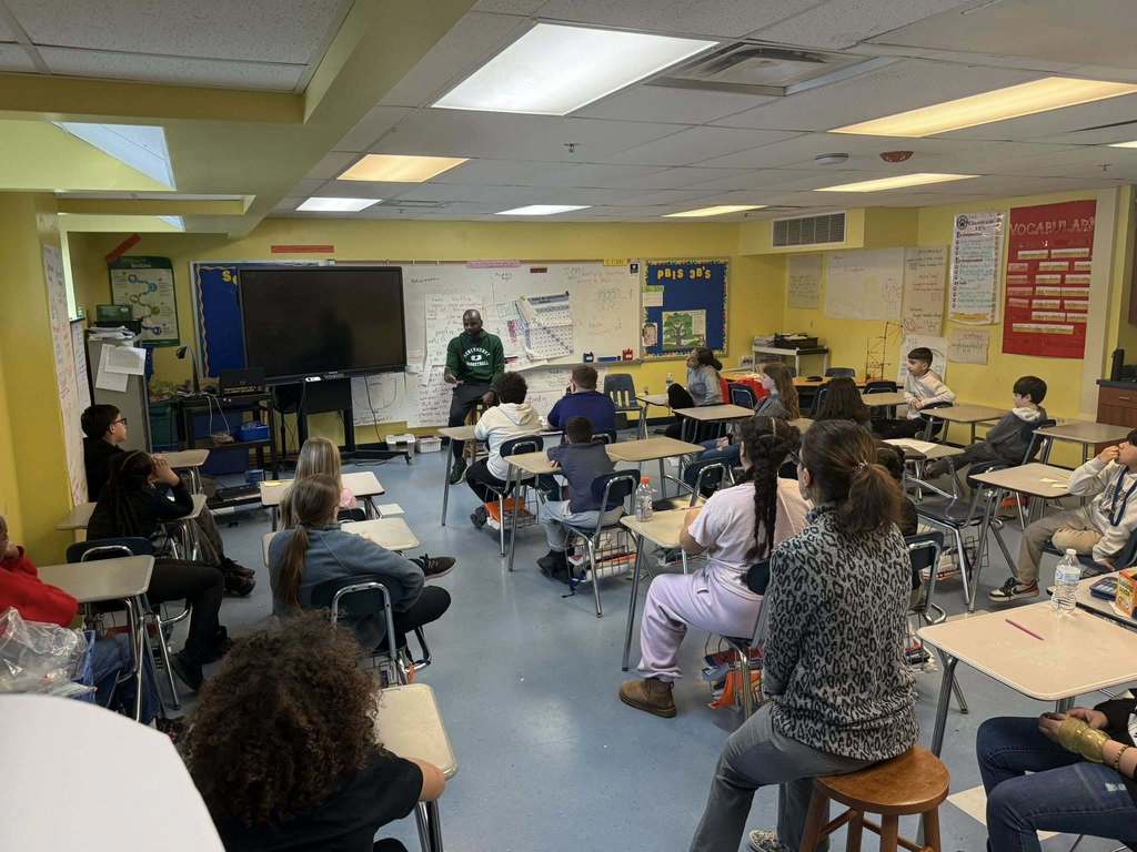 A man speaking to kids in a classroom.