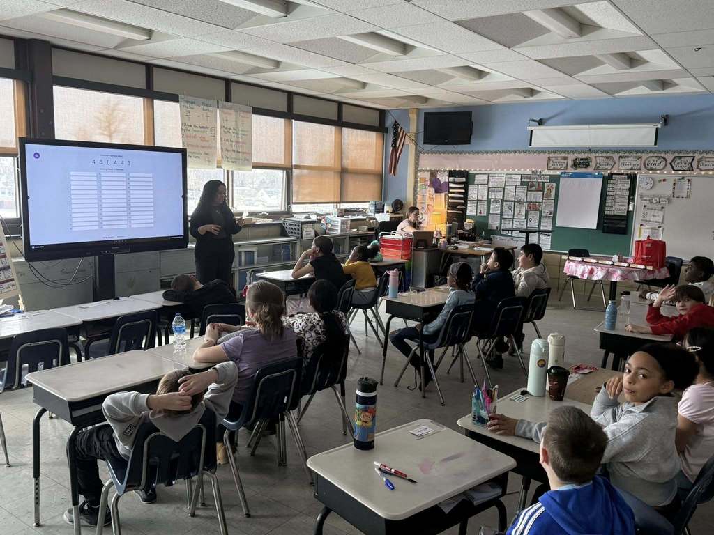 A women speaking to kids in a classroom.