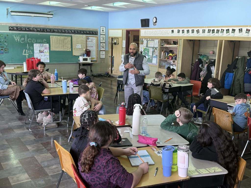 A man speaking to kids in a classroom.