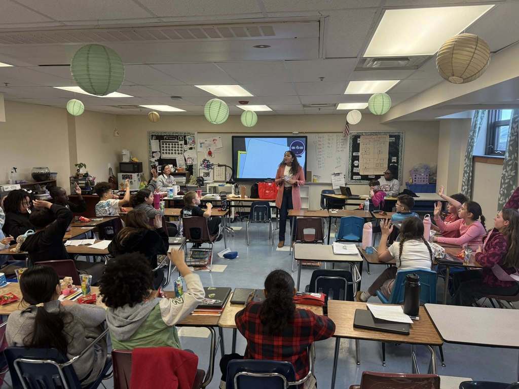 A women speaking to kids in a classroom.