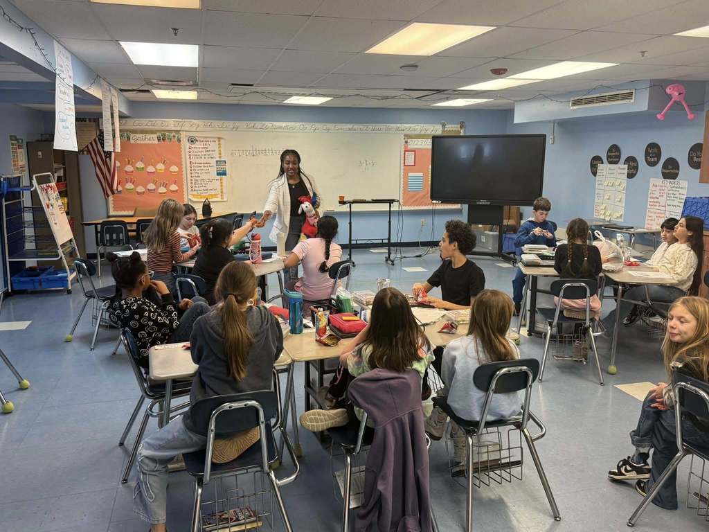 A women speaking to kids in a classroom.