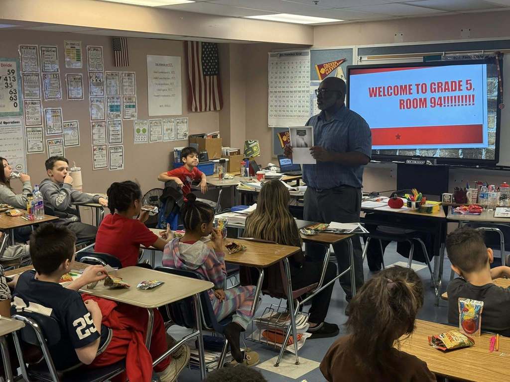 A man speaking to kids in a classroom.