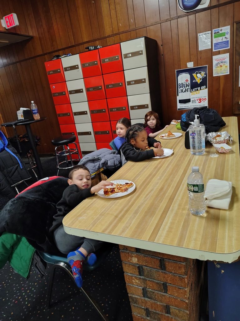 Kids eating at a bowling ally. 