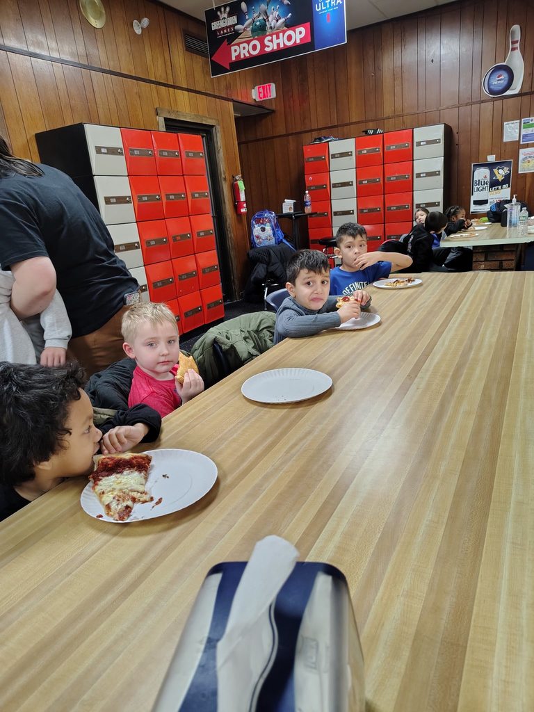 Kids eating at a long table. 