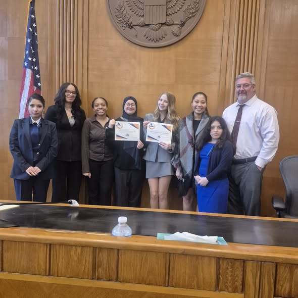 Group of students and adults in a courthouse.