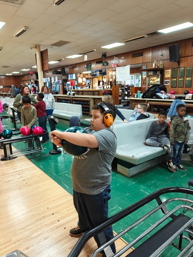 A student holding a bowling ball. 