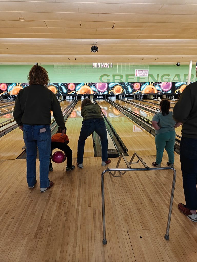 People bowling at a bowling ally. 