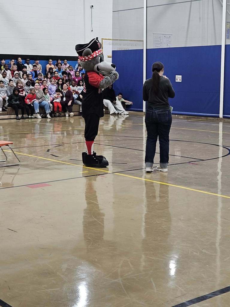 Erie SeaWolves mascot standing in the school gym. 