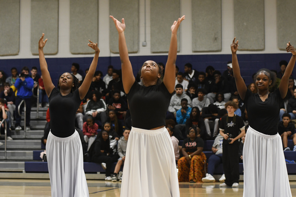 dancers with their arms raised above their heads