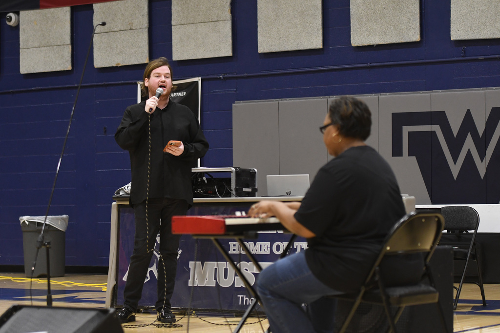 man singing while woman plays keyboard
