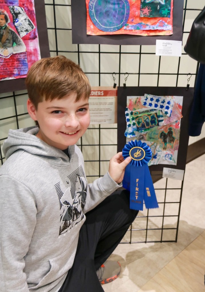 Student poses with winning artwork.