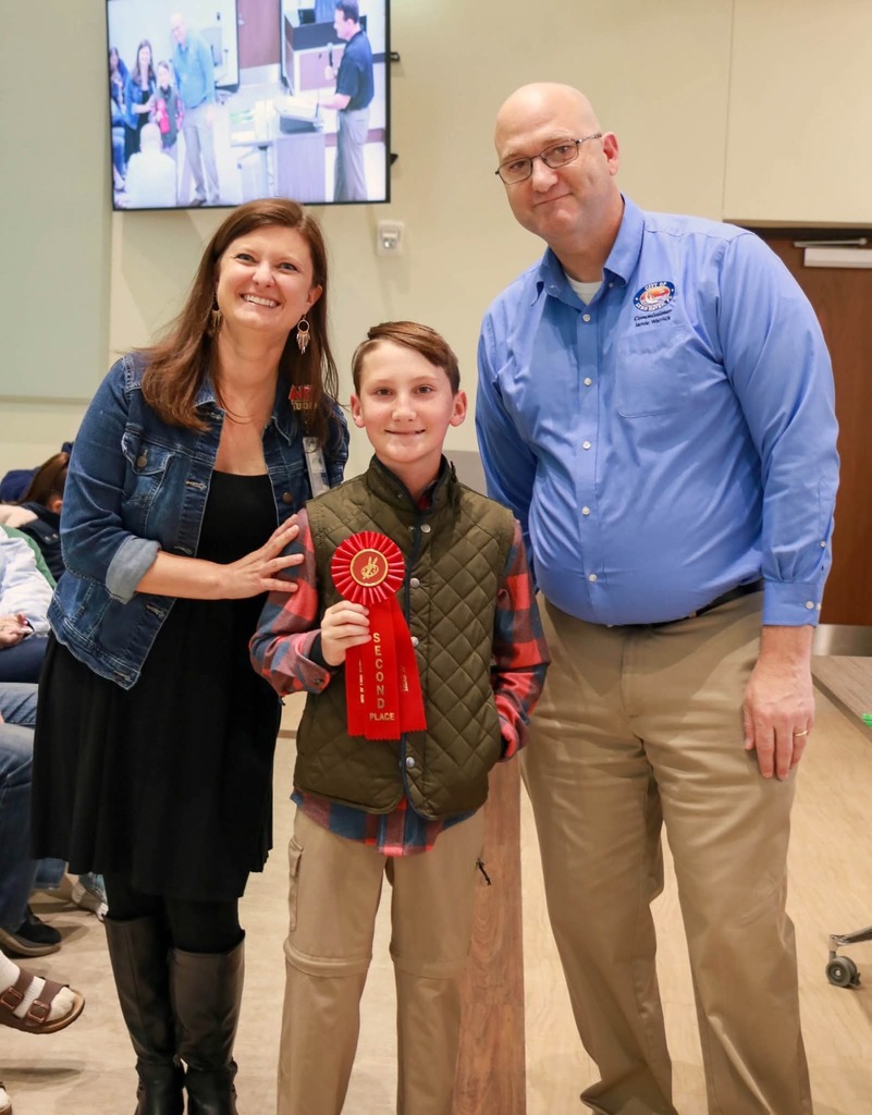 Student poses with teacher and city official.