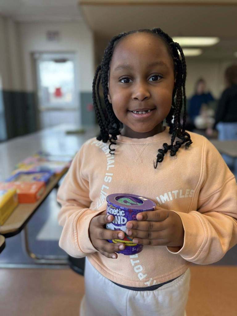 A kid holding a toy. 
