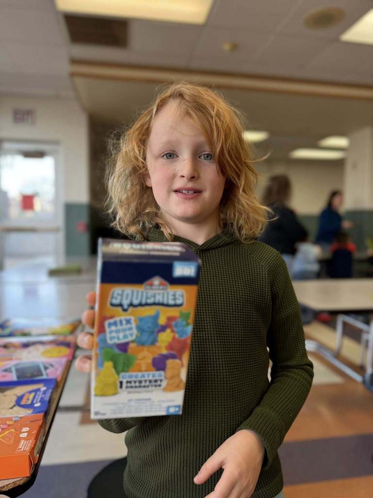 Kid holding a box of squishies. 