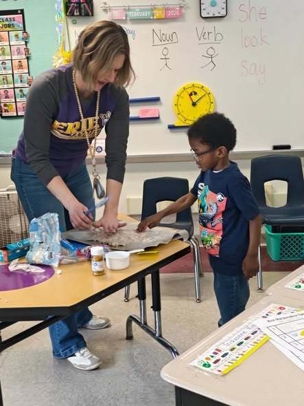 A teacher teaching students how to cook in class with hands on experience. 