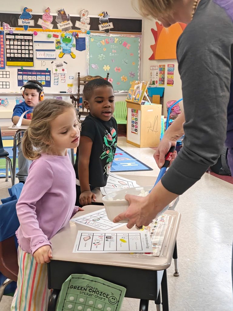A teacher teaching students how to cook in class with hands on experience. 