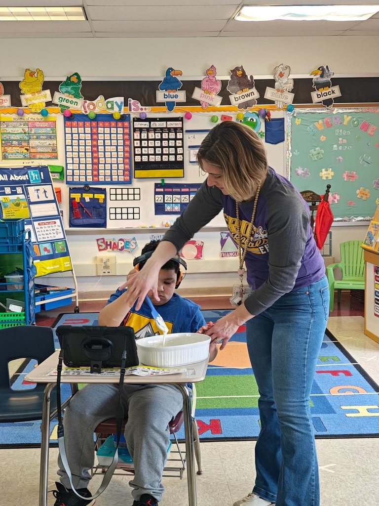 A teacher teaching students how to cook in class with hands on experience. 