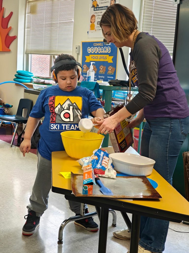 A teacher teaching students how to cook in class with hands on experience. 