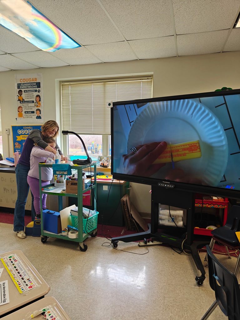 A teacher teaching students how to cook in class with hands on experience. 