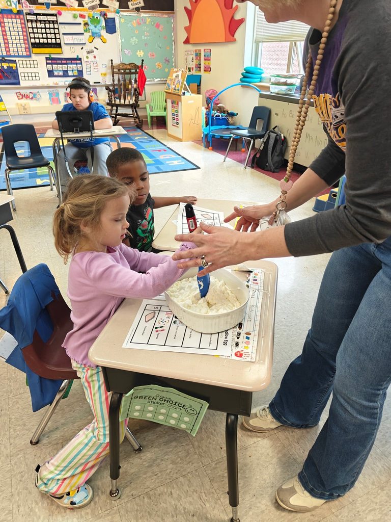 A teacher teaching students how to cook in class with hands on experience. 