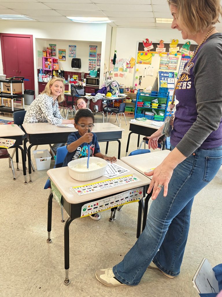 A teacher teaching students how to cook in class with hands on experience. 