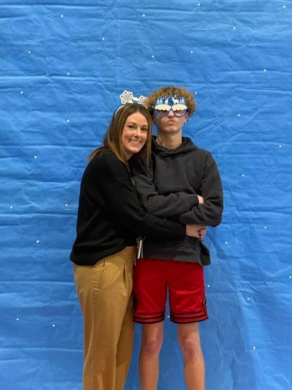 Two people taking a photo in front of a snow globe backdrop. 