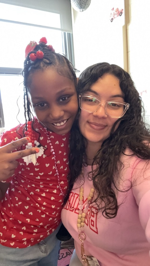 A teacher smiling with a student. 