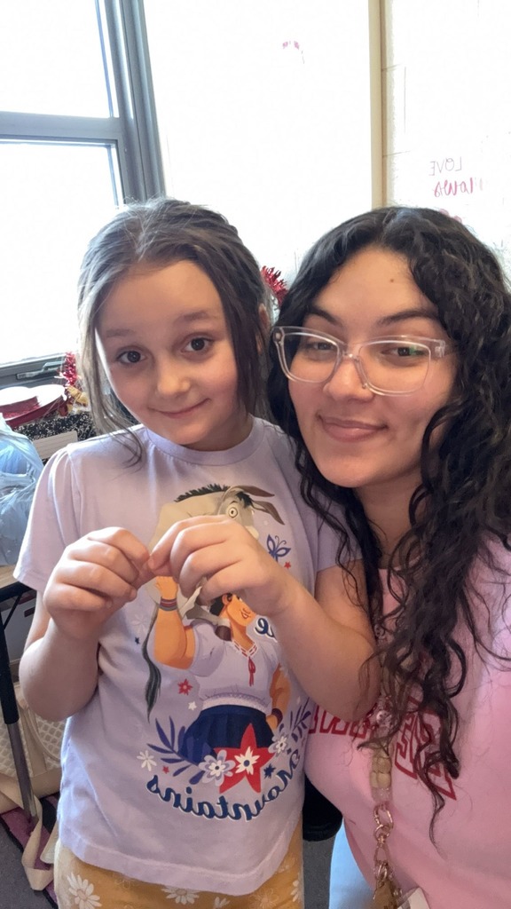 A teacher smiling with a student. 