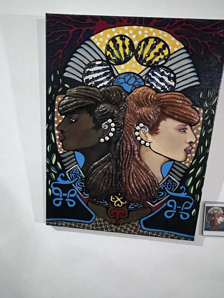 An art piece showing an African American lady and a white lady. 