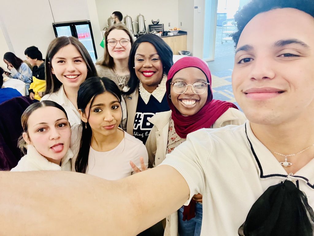 Dr. Natalyn Gibbs and students smiling. 