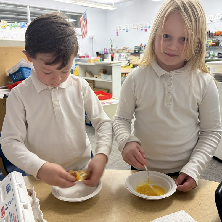 Students cracking open eggs.