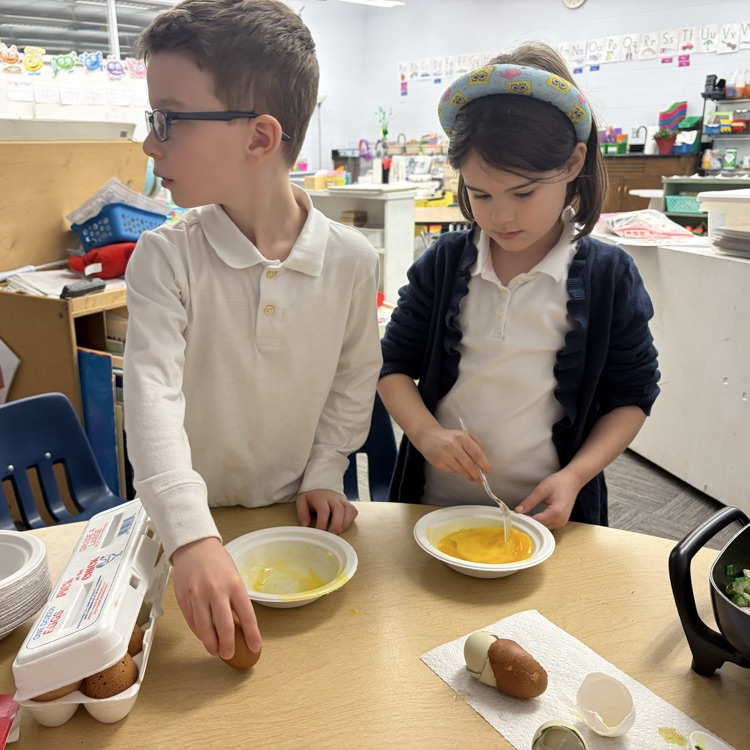 Students cracking open eggs.
