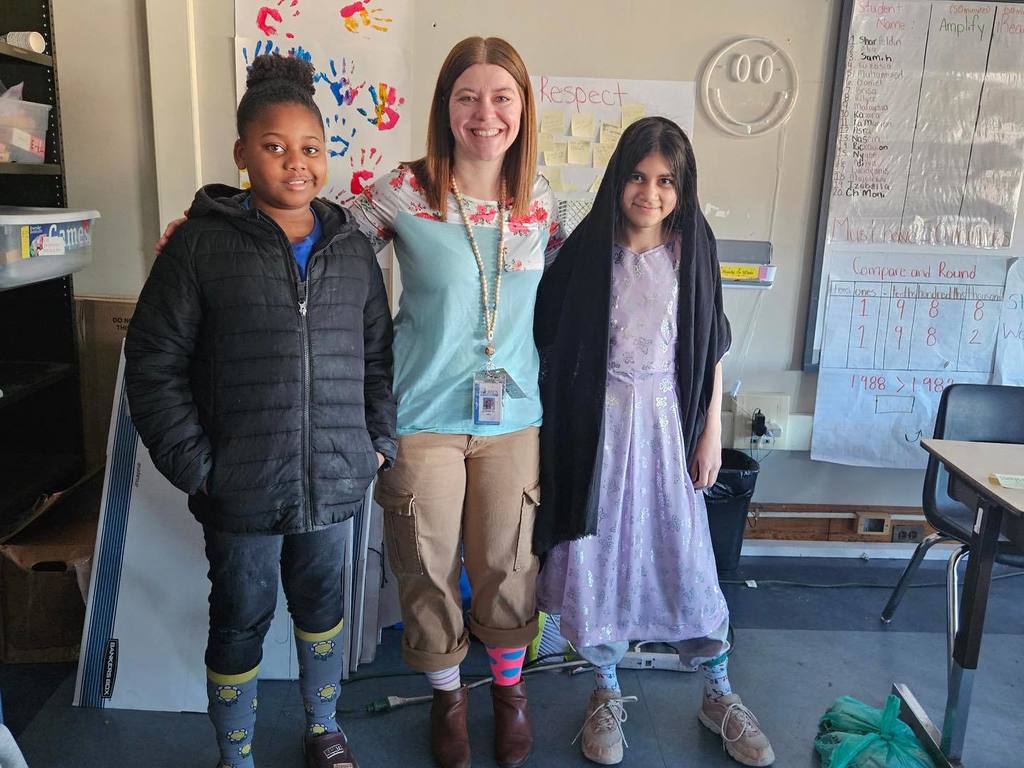 A teacher and two students wearing crazy socks.