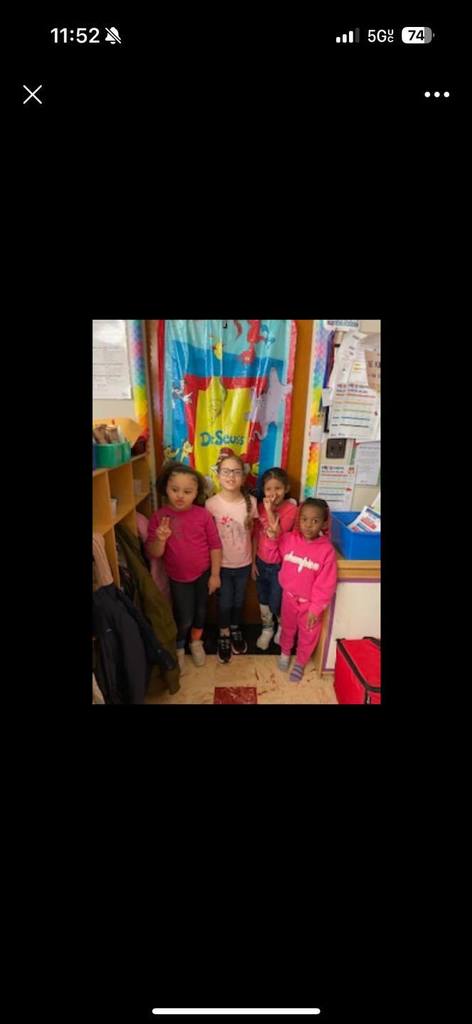 Kids smiling in a classroom and they are wearing crazy socks.