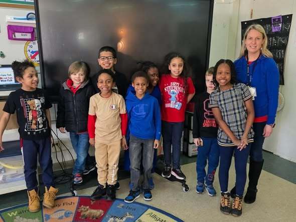 Students and a teacher all wearing red and blue. 