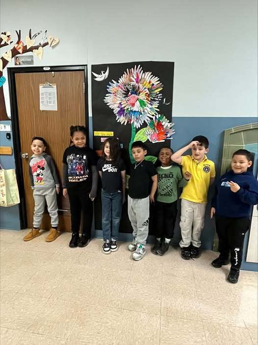 Kids smiling in a hall at school.