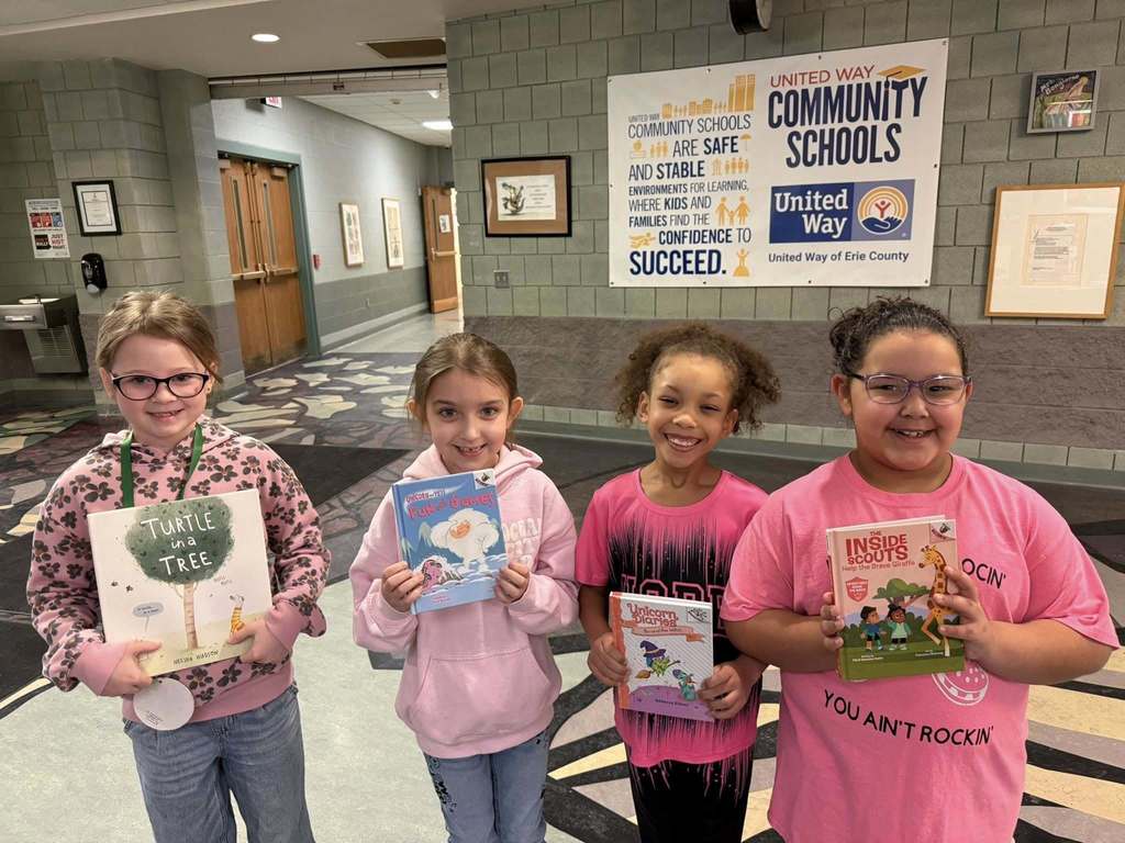 Students wearing pink are holding books. 