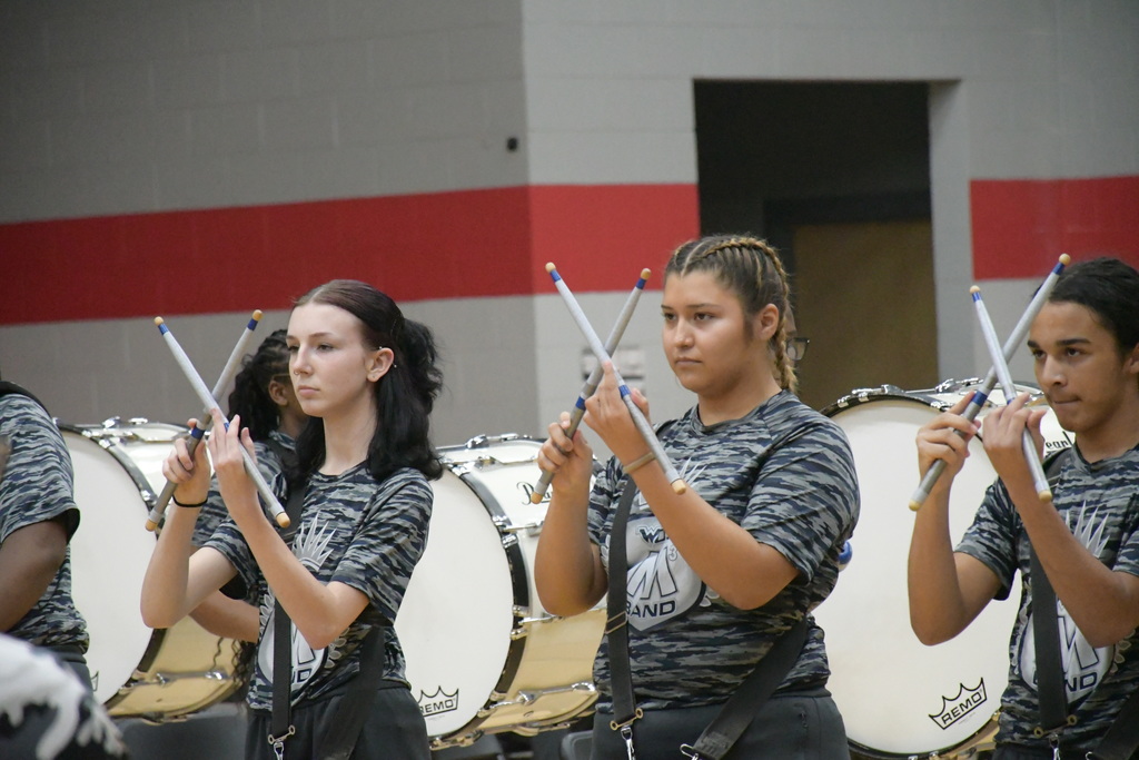WOS drumline making X's with their drumsticks