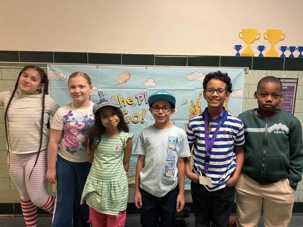 Students standing in the hall smiling. 