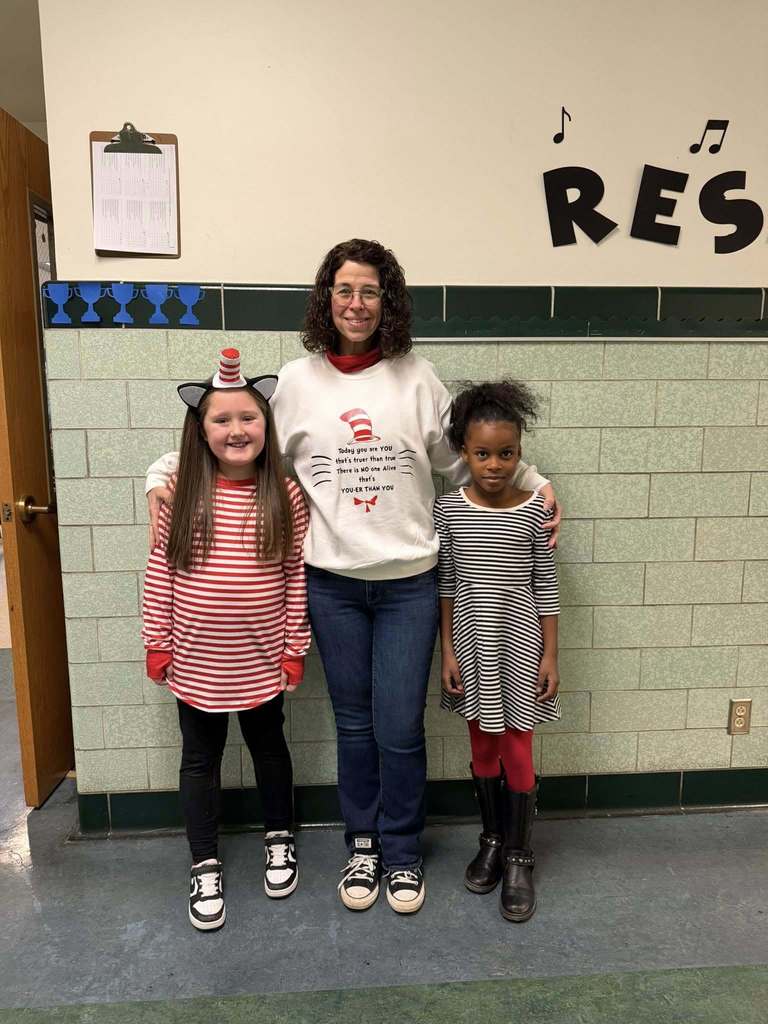 A teacher and students wearing cat in the hat clothing. 