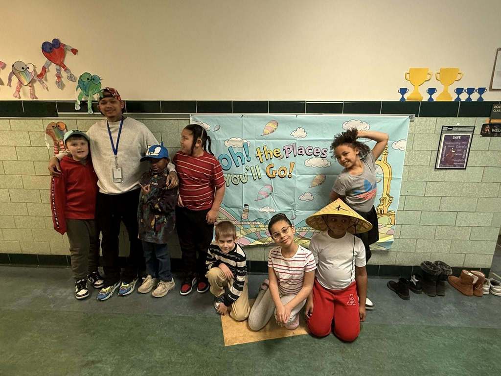 Some students and a teacher are wearing fun hats while other students are not.